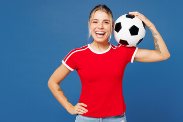 Young smiling cheerful woman fan wears basic red t-shirt cheer up support football sport team hold...