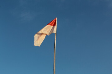 National Indonesian flag waving in the wind on blue sky background