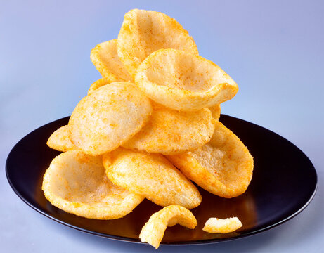 Krabbenchips gestapelt auf schwarzem Teller, kroepoek, chips, 