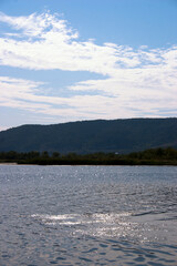 landscape of lake and blue sky with white clouds on a sunny day