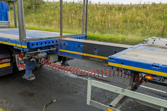 Blue HGV lorry truck extendable flatbed trailer being extended at roadside for wind turbine route test