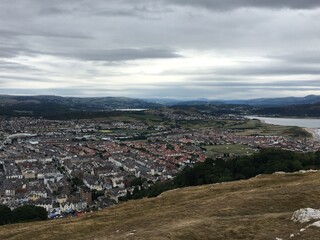 Expansive View Over a Coastal Town and Surrounding Landscape Under a Dramatic Sky