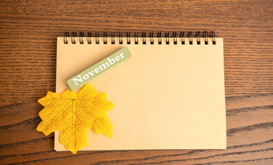 Autumn yellow leaf, November block on a notebook. The last third month of autumn, day of the year...