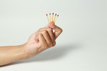 Male hand holding match sticks on isolated white background