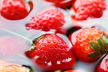Fresh Ripe Strawberries Floating in Clear Water with Soft Ripples, Highlighting Their Juicy Texture, Brilliant Red Color, and Natural Glossy Finish for Culinary, Healthy, or Organic Themes