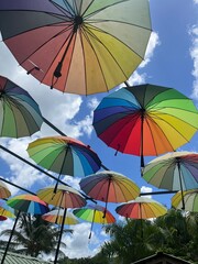 Vibrant Multicolored Umbrellas Suspended Against a Clear Blue Sky