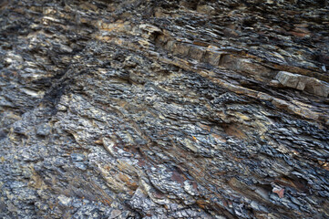 Close-up of layered sedimentary rock formations with diverse textures and natural color tones....