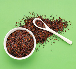 Brown mustard seeds in bowl and spoon - Brassica juncea.