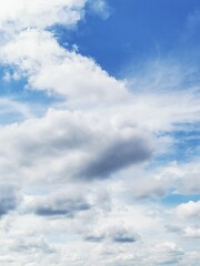Fototapeta premium Beautiful fluffy clouds in a clear blue sky above a peaceful landscape during a sunny day in early autumn
