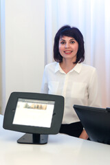 Woman hotel counter greeting and guiding guests to their hotel rooms.