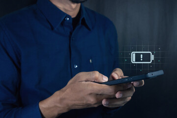 Man using a mobile phone with with a low battery charge icon on the virtual screen