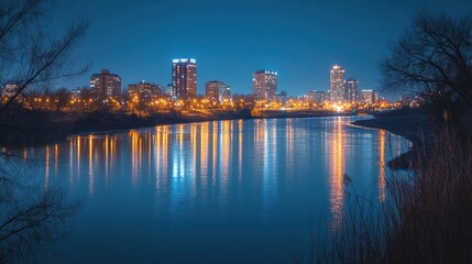 Fototapeta premium A city skyline at night with lights reflecting off the river, capturing urban life.