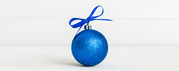 Christmas ball on colored background. decoration bauble with ribbon bow with copy space
