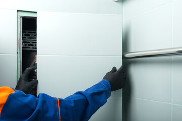 worker closes hidden door in bathroom after plumbing repair