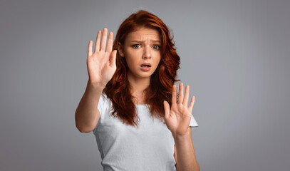 No. Scared Red-Haired Girl Gesturing Stop Forbidding Or Warning About Danger Standing On Gray Background. Studio Shot