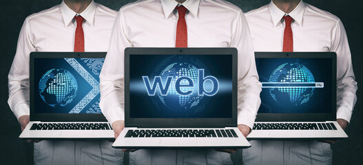 Businessman in suit holding laptop with web development hologram