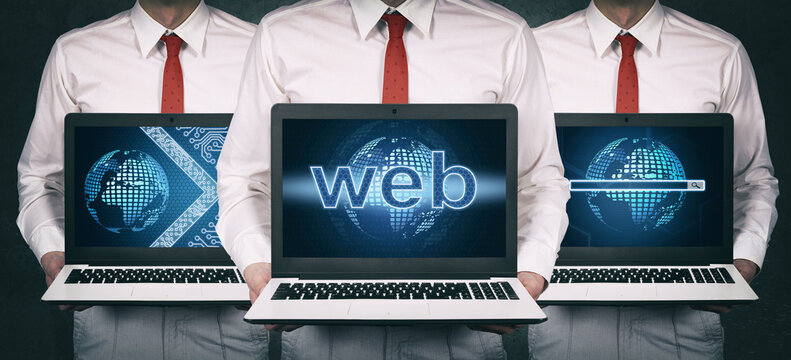 Businessman in suit holding laptop with web development hologram