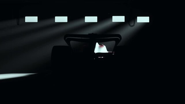 Dramatic beams of light illuminate a sleek red race car in a dark garage