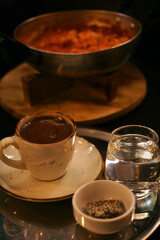a tray with a cup of coffee, water and sweets. Turkish breakfast in the cafe
