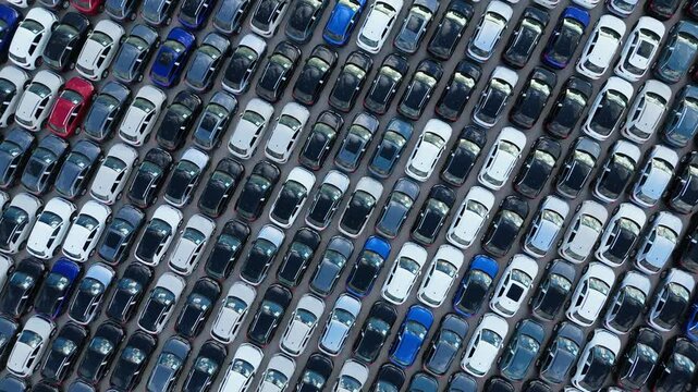 Colorful New Cars on Large Parking Lot in Port Ready for Distribution to Dealer. Automotive Industry Business. Aerial Overhead Top-Down Drone Shot. Moving Upwards, Rotation