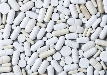 Mix of medical capsules and pills on grey top view. Taking dietary supplements and medicines