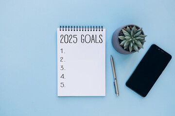2025 New Year goals background with blank notebook, pen, smartphone and plant. Space for text. Top view. Christmas to-do list or wish list