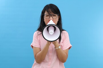 Social injustice. Angry young asian woman using a megaphone to give a loud message or announcement