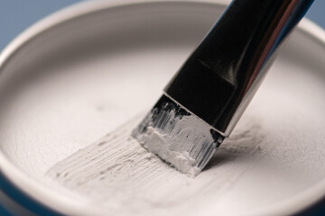 White paste and brush for marking the shape of the eyebrows, close-up. Professional makeup and...