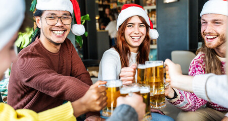 Happy friends wearing santa claus hat having Christmas dinner party- Cheerful young people sitting...