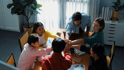 Top view of business team brainstorming idea by using mind map while putting hand together. People designing Ux Ui design for mobile phone while making stack of hands and clapping hand. Convocation.