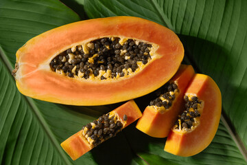 Vibrant closeup photo of ripe papaya fruit, beautifully sliced to reveal its juicy orange flesh and dark seeds. Tropical ambiance of papaya fruit is perfect for dessert or Thai cuisine visuals.