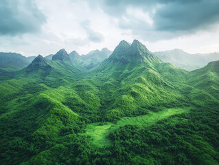 Fototapeta premium Lush green mountains with rugged peaks and valleys create stunning landscape. vibrant greenery and dramatic terrain evoke sense of tranquility and adventure