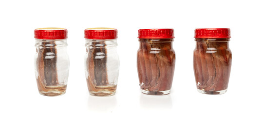 Canned anchovy fillet in small glass jar, marinated fish, traditional salted anchovy in oil on white