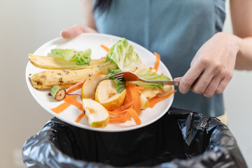 Compost from leftover food in the meal in household, female hand holding left over meal use fork...
