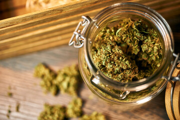 Medical cannabis on a wooden table, green dry buds, cbd oil, healing tincture, cannabinoids
