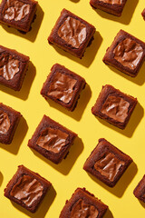 Obraz premium Creative pattern of square-shaped brownies on a yellow background.