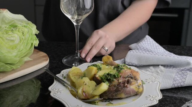 Roasted Duck Leg with Herbs and White Wine Gourmet Dining Experience. Succulent roasted duck leg seasoned with fresh herbs and paired with potatoes, served alongside a glass of white wine. 