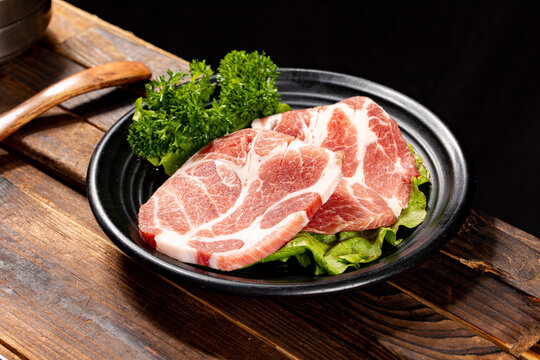 Thick-cut Korean pork neck (moksal) being grilled on a hot plate. A popular cut for Korean barbecue with tender texture and balanced marbling, often served with dipping sauce and fresh vegetables.
