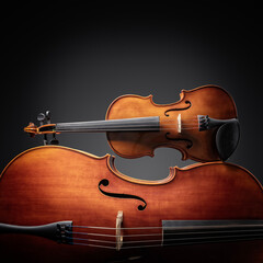 Cello and violin on black background with copy space for concert poster, music album or cd cover