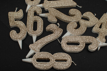 Birthday numeral candles on black background	