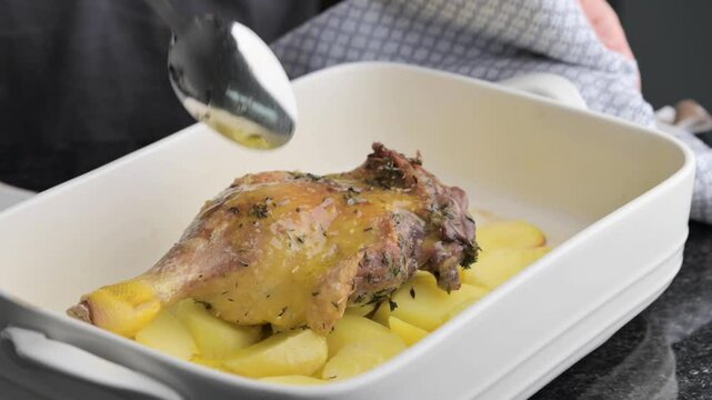 Roasted Duck Leg with Potatoes and Herbs Gourmet OvenbBaked Dish. elicious video of a duck leg being prepared,potatoes and aromatic herbs, roasted to in the oven.for food blogs,tutorials,media content