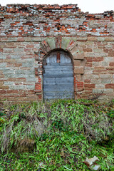 Rustic boarded archway in a weathered wall evokes a sense of forgotten architecture