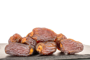 Several sweet dried pitted dates with slate stone, macro, isolated on white background.