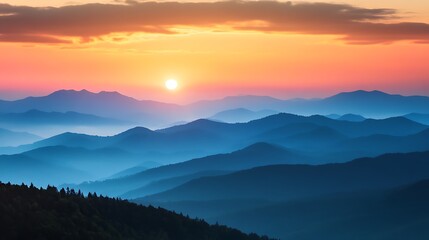 Obraz premium Sunrise over a mountain range with a layer of mist creating a serene, peaceful and inspiring image.