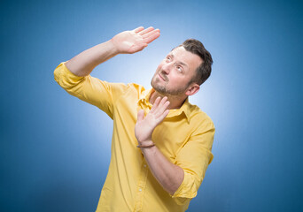Discrimination. Young man looking up to boss and defending herself over blue background, dresses in...