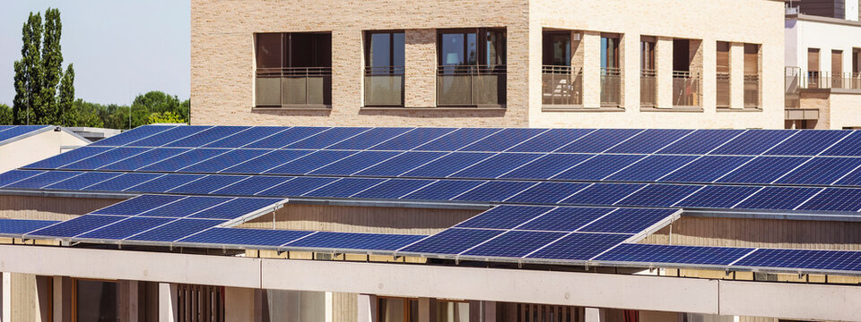 Solar Panel Installation on Smart Building Background in Green City. Modern Solar City concept.