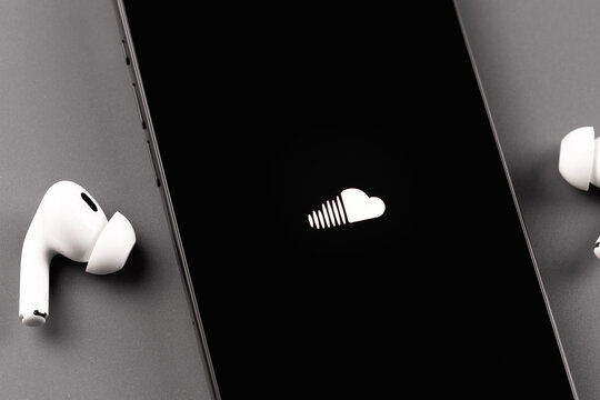 Soundcloud logo mobile app on a screen smartphone iPhone with Apple AirPods closeup. SoundCloud is a global online audio distribution platform. Batumi, Georgia - August 11, 2024