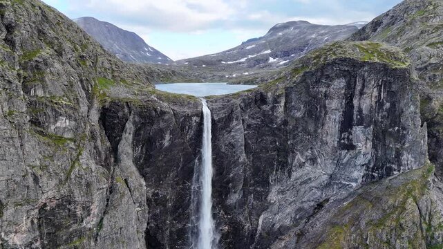 The drone zooms in and rises slowly behind mountains and Mardalsfossen in Eikesdal comes into view. The waterfall is one of the tallest waterfalls in Europe. A whopping 705 meters of waterfalls. 4K.