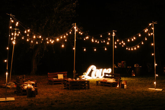 White lighted string lights on brown wooden bench during night time