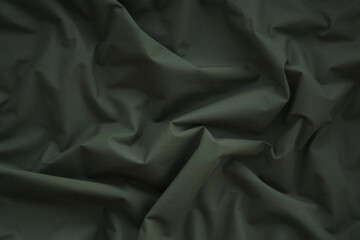 Texture of Dark green military uniform textile cloth with folds